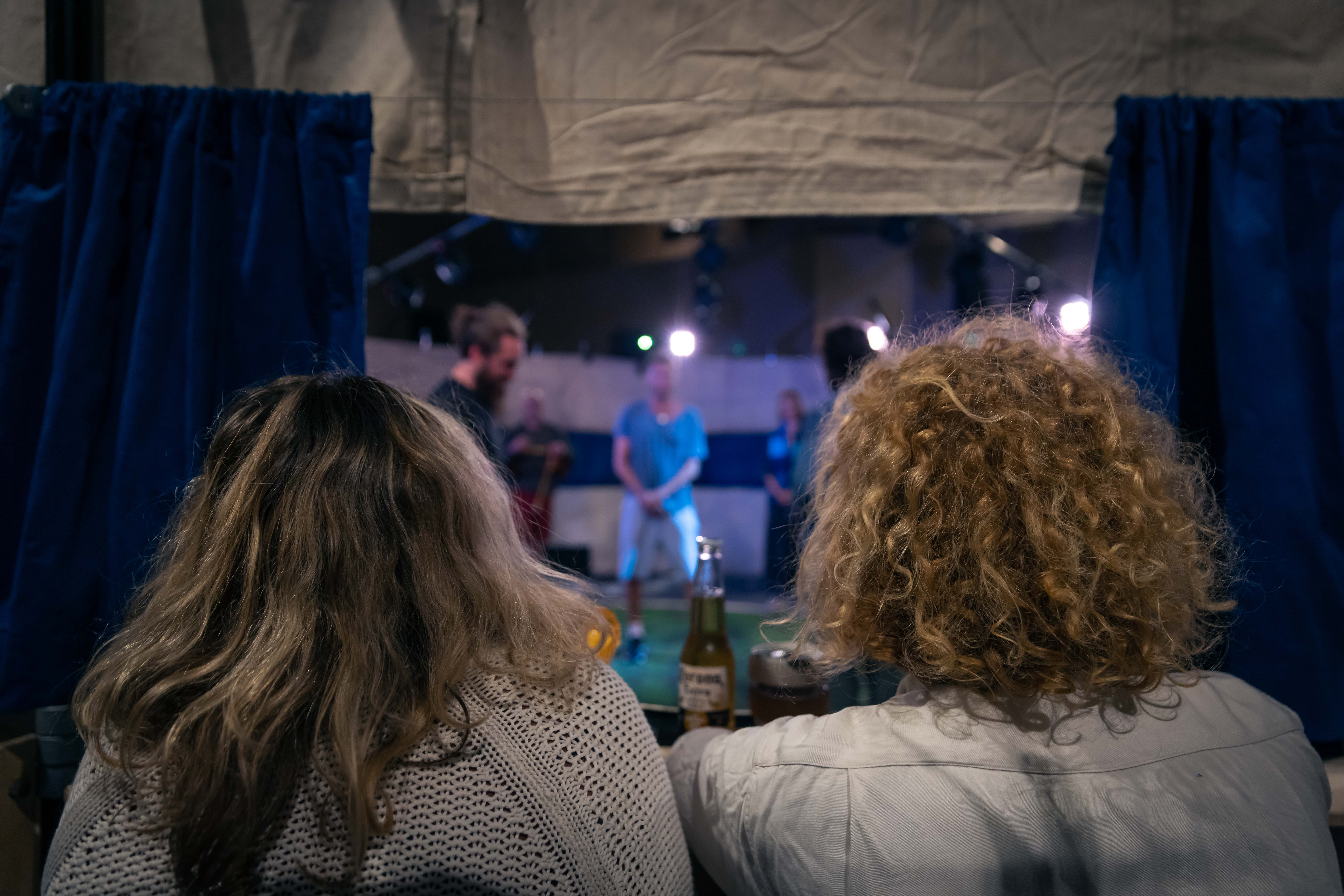Two spectators watch Everyman from one of our booths in the Fleapit, a bespoke performance structure